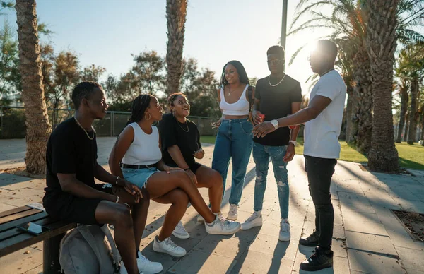 Grupo de jóvenes amigos negros africanos modernos felizmente sentados juntos —  Fotos de Stock