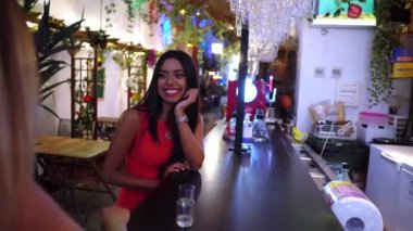 İki çekici genç bayan arkadaş birlikte kokteyl içiyorlar.