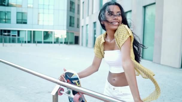 Pretty athletic girl rides a longboard in modern city — Stock Video