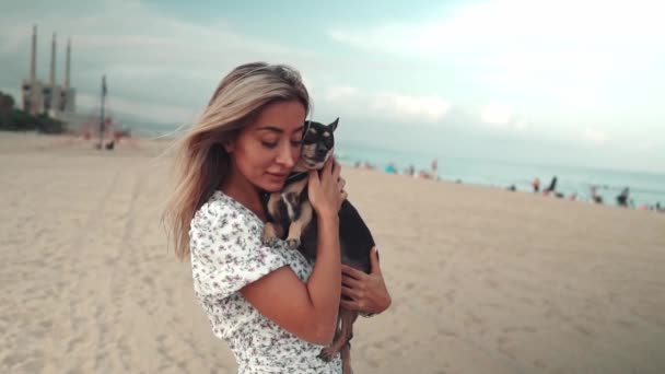 所有者とアーサーという名前の小さな犬,若い女性,ビーチで遊んで — ストック動画