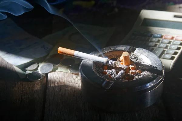 Sigara ve para ile hesap makinesi. kavram sigara yıl ay ve gün satın almak için ödeme ne kadar maliyet