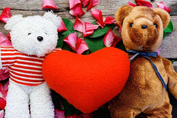 Two Toy bear doll have falling in love with Rose petals background in  valentine day.
