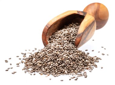 Beyaz arka planda izole edilmiş tahta kaşıkta chia tohumları ve chia tohumları yığını..