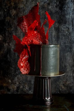 Savurgan pasta siyah renkli parlak kırmızı karamel dekora sahip. Göz alıcı Doğum günü pastası