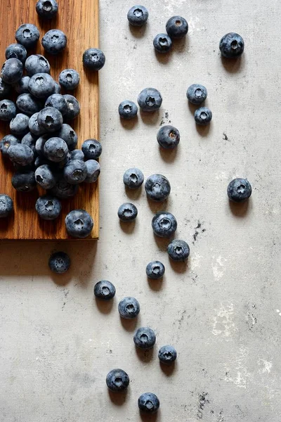 Organik Yaban mersini çilek bir ahşap tahta üzerinde. Yaz hafif tatlı çilek gri bir arka plan üzerinde. Sağlıklı gıda. Yaz ve sağlık