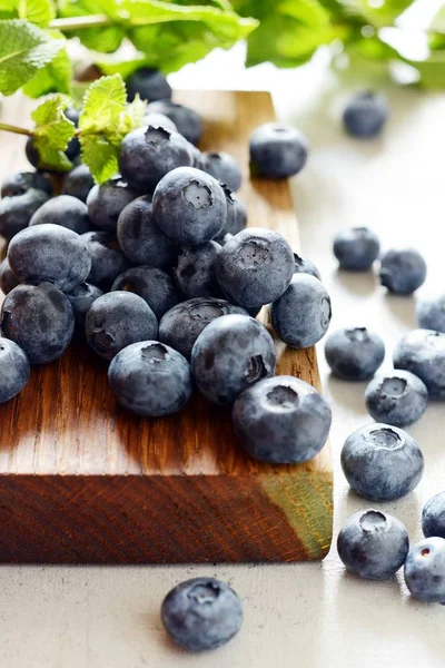 Organik Yaban mersini çilek bir ahşap tahta üzerinde. Yaz hafif tatlı çilek gri bir arka plan üzerinde. Sağlıklı gıda. Yaz ve sağlık