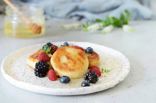  Pazar kahvaltısı peynirli kek, bal, taze meyveler ve nane ile. Krep peynir veya lor börek bal ve çilek plaka mavi masa üstü görünümünde dekore edilmiştir. Sağlıklı ve diyet kahvaltı.