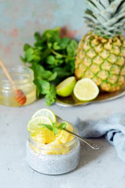 Kahvaltı masası Chia meyve smoothies kase adet ananas, kireç, bal ve nane yaprakları ile. Sağlıklı gıda. Üstten görünüm, boş yer