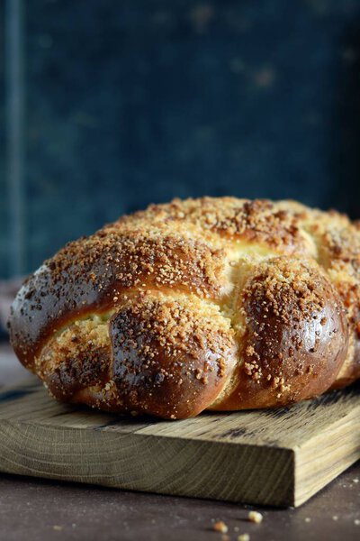 Challah or Hala is a traditional jewish sweet fresh sabbath bread loaf,  fresh bun on cutting board. Brioche bread on breakfast table. The golden glaze of these baked brioche buns boasts 