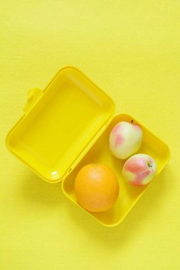 Yiyeceklerle beslenme çantası. Olgun portakal suyu ve elma sarı bir arka plan üzerinde. Üstten görünüm, düz yatıyordu, paket servisi olan restoran gıda, kopya alanı