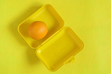 Yiyeceklerle beslenme çantası. Sarı bir arka plan üzerinde olgunlaşmış portakal suyu. Üstten görünüm, düz yatıyordu, paket servisi olan restoran gıda, kopya alanı