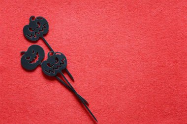 Kırmızı bir arka plan kopya alanı üzerinde Halloween balkabağı şeklinde ahşap şişleri