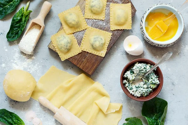 Raviolli ricotta ve ıspanak bir mavi arka plan, geleneksel İtalyan mutfağı, üstten görünüm ile ev yapımı makarna pişirme