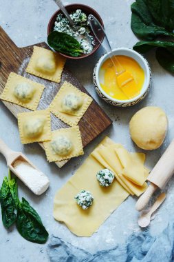 Raviolli ricotta ve ıspanak bir mavi arka plan, geleneksel İtalyan mutfağı, üstten görünüm ile ev yapımı makarna pişirme