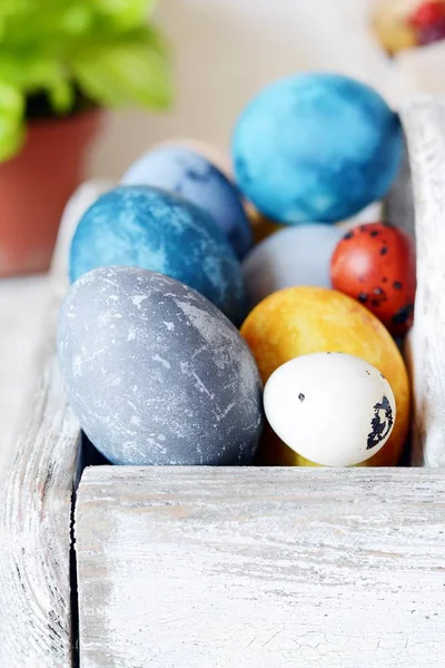 Colored Easter eggs in a wooden basket on a white background. Happy easter. Easter decoration.