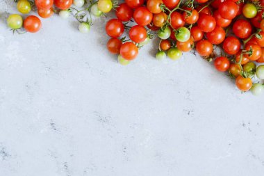 Taze kiraz domates üzerinde gri bir arka plan, duvar kağıdı, kırmızı kiraz domates domates. Kopya alanı ile üstten görünüm.