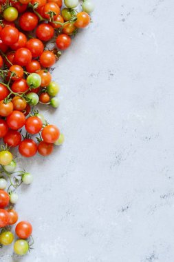 Taze kiraz domates üzerinde gri bir arka plan, duvar kağıdı, kırmızı kiraz domates domates. Kopya alanı ile üstten görünüm.