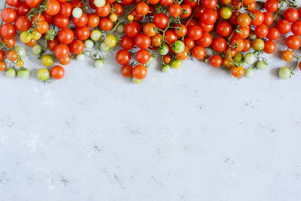 Fresh cherry tomatoes on a gray background, cherry tomatoes for wallpaper, red cherry tomatoes. Top view with copy space.