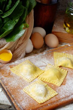 Lezzetli çiğ Mantı ricotta ve ıspanak, un ve yumurta ahşap arka plan ile. İtalyan ravioli yapma işlemi. Taze yumurta makarna ev yapımı hazırlık, pişirme ham mantı, rustik gıda.