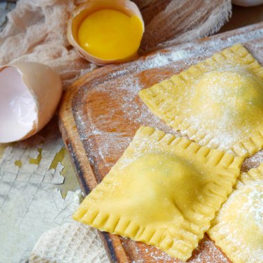 Lezzetli çiğ Mantı ricotta ve ıspanak, un ve yumurta ahşap arka plan ile. İtalyan ravioli yapma işlemi. Taze yumurta makarna ev yapımı hazırlık, pişirme ham mantı, rustik gıda.
