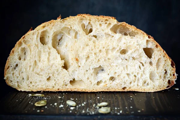 Fresh homemade bread on a dark background, on whole wheat flour. French bread round shape. Bread baking. Unleavened bread