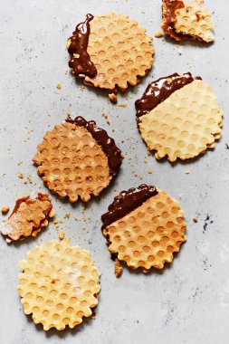 Tuzlu karamelli Hollanda gözlemeleri, tuzlu karamel ile Hollanda gözlemeleri, fındık ve gri arka planda siyah çikolata. Lezzetli çıtır tatlı. Düz yatıyordu