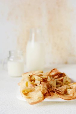 Hafif arka planda kahvaltıda böğürtlenli, ballı ve sütlü ev yapımı krepler. Geleneksel mutfak. Krep haftası. Shrovetide Maslenitsa Tereyağı Haftası Festival Yemeği.