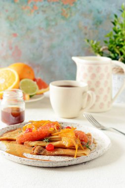 Turuncu Karamel Sos, portakal dilimleri, limon ve portakal lezzet ve bir fincan kahve ile Kahvaltıda krep Suzette krep. Tatlı Fransız mutfağı. Pazar günü kahvaltı