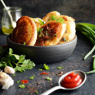 Kıyılmış et parçaları, dereotu, maydanoz ve yeşil soğan, sarımsak, domates sosu ve karanlık bir arka plan üzerine pul biber ile ev yapımı lezzetli gözleme. Snack seçenek krep. Kıyılmış etli börek