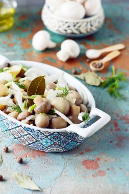 Soğan, biber, dereotu ve gri-mavi zemin üzerine zeytin yağı ile güzel bir kase lezzetli Marine mantar görünümü, petrol top