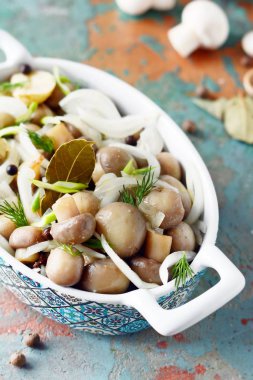 Soğan, biber, dereotu ve gri-mavi zemin üzerine zeytin yağı ile güzel bir kase lezzetli Marine mantar görünümü, petrol top