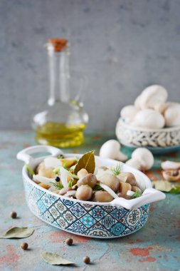 Soğan, biber, dereotu ve gri-mavi zemin üzerine zeytin yağı ile güzel bir kase lezzetli Marine mantar görünümü, petrol top