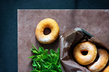 Beyaz arka planda şeker kremalı ve nane yapraklı klasik taze çörekler..