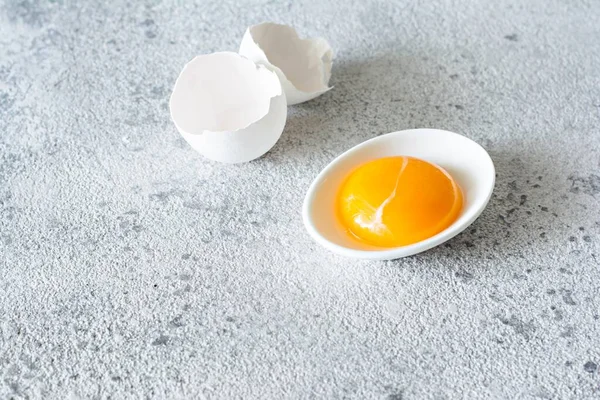 Gema Ovo Uma Tigela Branca Com Uma Concha Fundo Cinza — Fotografia de Stock