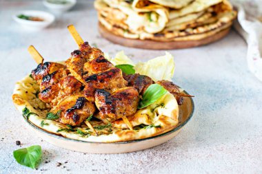 Izgara tavuk kebabı (tavuk şişi) ve sarımsaklı tereyağlı naan tortillası ve Yunan tzatziki sosu. Lezzetli sokak yemekleri.