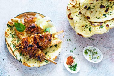 Izgara tavuk kebabı (tavuk şişi) ve sarımsaklı tereyağlı naan tortillası ve Yunan tzatziki sosu. Lezzetli sokak yemekleri.