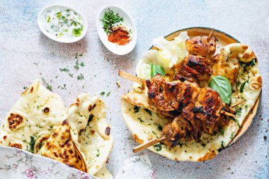 Izgara tavuk kebabı (tavuk şişi) ve sarımsaklı tereyağlı naan tortillası ve Yunan tzatziki sosu. Lezzetli sokak yemekleri.
