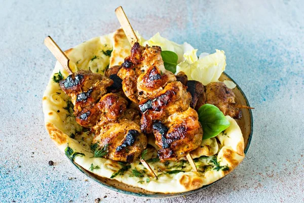 Izgara tavuk kebabı (tavuk şişi) ve sarımsaklı tereyağlı naan tortillası ve Yunan tzatziki sosu. Lezzetli sokak yemekleri.