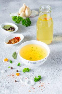 Hafif arka planda sebze, baharat ve bitki içeren ev yapımı tavuk (kemik) çorbası (bouillon). Hayvan kaynaklı doğal kolajen. Et, balık ve sebzelerden sıvı et suyu..