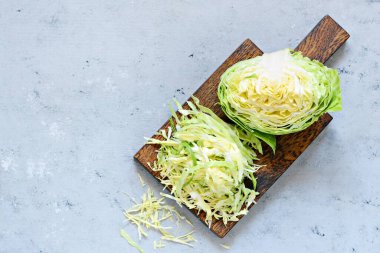 Ahşap mutfak tahtasındaki taze lahana mavi arka planda öğütülmek için. Salata kesmek için sebze. Vejetaryen yemeği, diyet, vitamin.