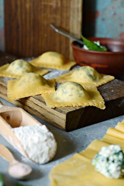 Mavi arka planda taze çiğ Ravioli, Ricotta ve ıspanak. Ev yapımı çiğ İtalyan makarnalı ravioli. İtalyan yemeği..