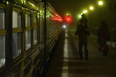 Dubna, Rusya Federasyonu - 5 Kasım, 2018: Dubna tren istasyonunda gece yoğun sis içinde yolcu ve banliyö treni.