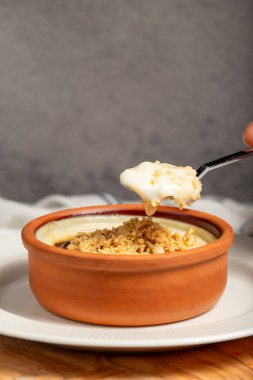 Sütlaç. Sütlü tatlı. Fırında pişmiş sütlaç, kilden bir kasede.