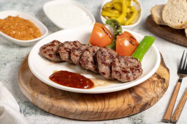 Izgara köfte. Domates, biber, aperatif ve özel sosla. Tabakta Türk köftesi