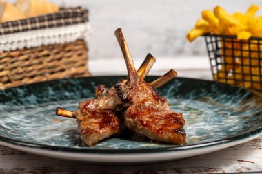 Taze ızgara kuzu pirzolası. Ahşap arka planda pişmiş kuzu pirzolası dilimleri. yüksek kaliteli fotoğraf. Kapat.