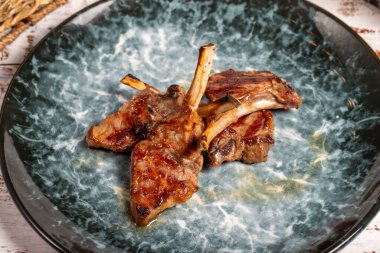 Taze ızgara kuzu pirzolası. Ahşap arka planda pişmiş kuzu pirzolası dilimleri. yüksek kaliteli fotoğraf. Kapat.