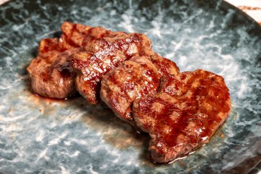 Taze ızgara sığır filetosu dilimleri. Ahşap arka planda pişirilmiş fileto dilimleri. yüksek kaliteli fotoğraf. Kapat.