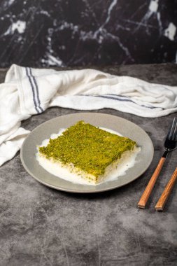 Şam fıstıklı soğuk kadayif. Siyah arka planda fıstıklı sütlü kadayf tatlısı. Yerel adı Soguk Kadayif Tatlisi. Üst görünüm