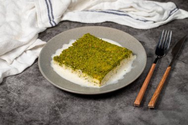 Şam fıstıklı soğuk kadayif. Siyah arka planda fıstıklı sütlü kadayf tatlısı. Yerel adı Soguk Kadayif Tatlisi. Üst görünüm