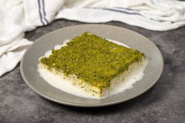 Şam fıstıklı soğuk kadayif. Siyah arka planda fıstıklı sütlü kadayf tatlısı. Yerel adı Soguk Kadayif Tatlisi. Üst görünüm